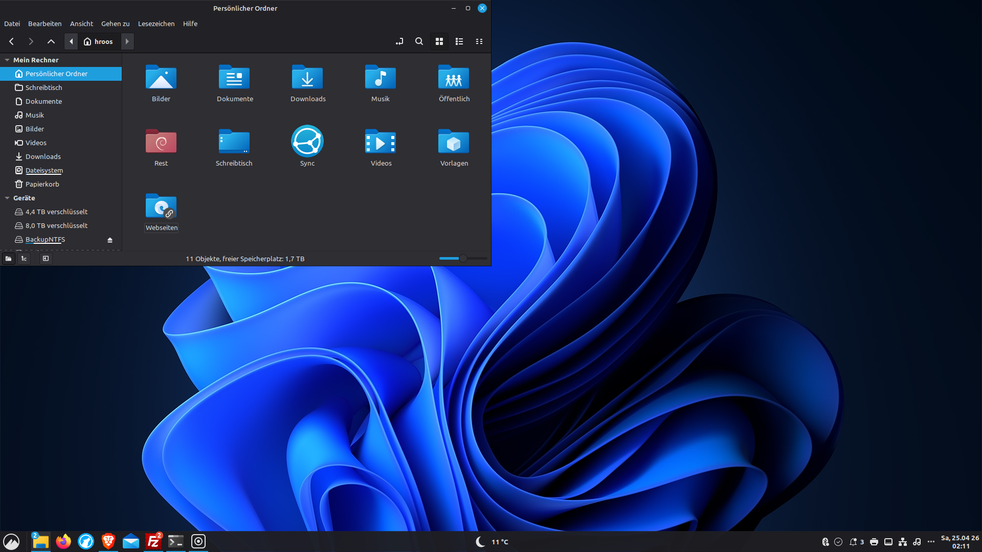 Linux Mint Desktop mit Windows-11-ähnlichem Erscheinungsbild: dunkles Design, blaues Hintergrundbild, Windows-Icons, Dateimanager geöffnet